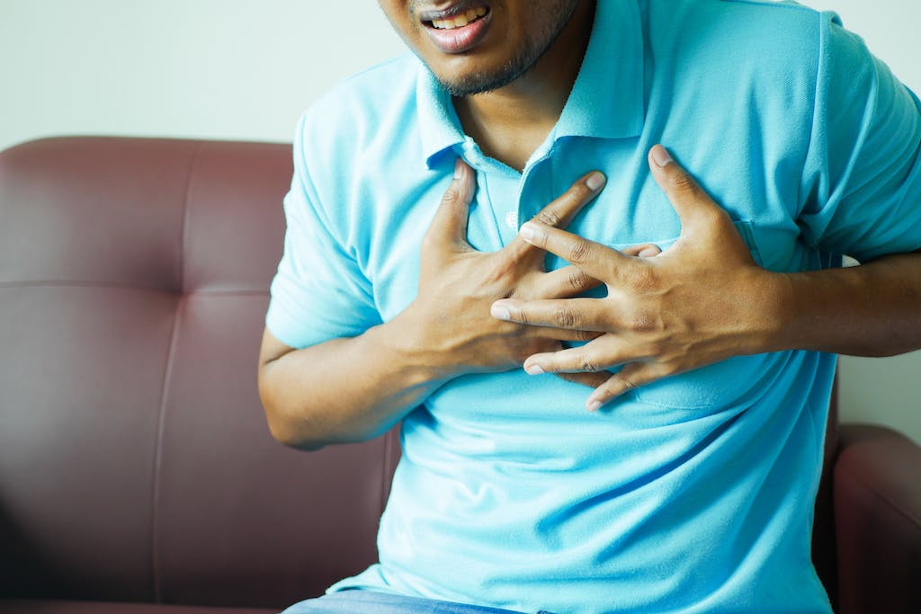 Close-up of a Man in Blue Polo Shirt with Hands on Chest